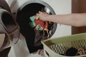 donna con bucato in lavatrice