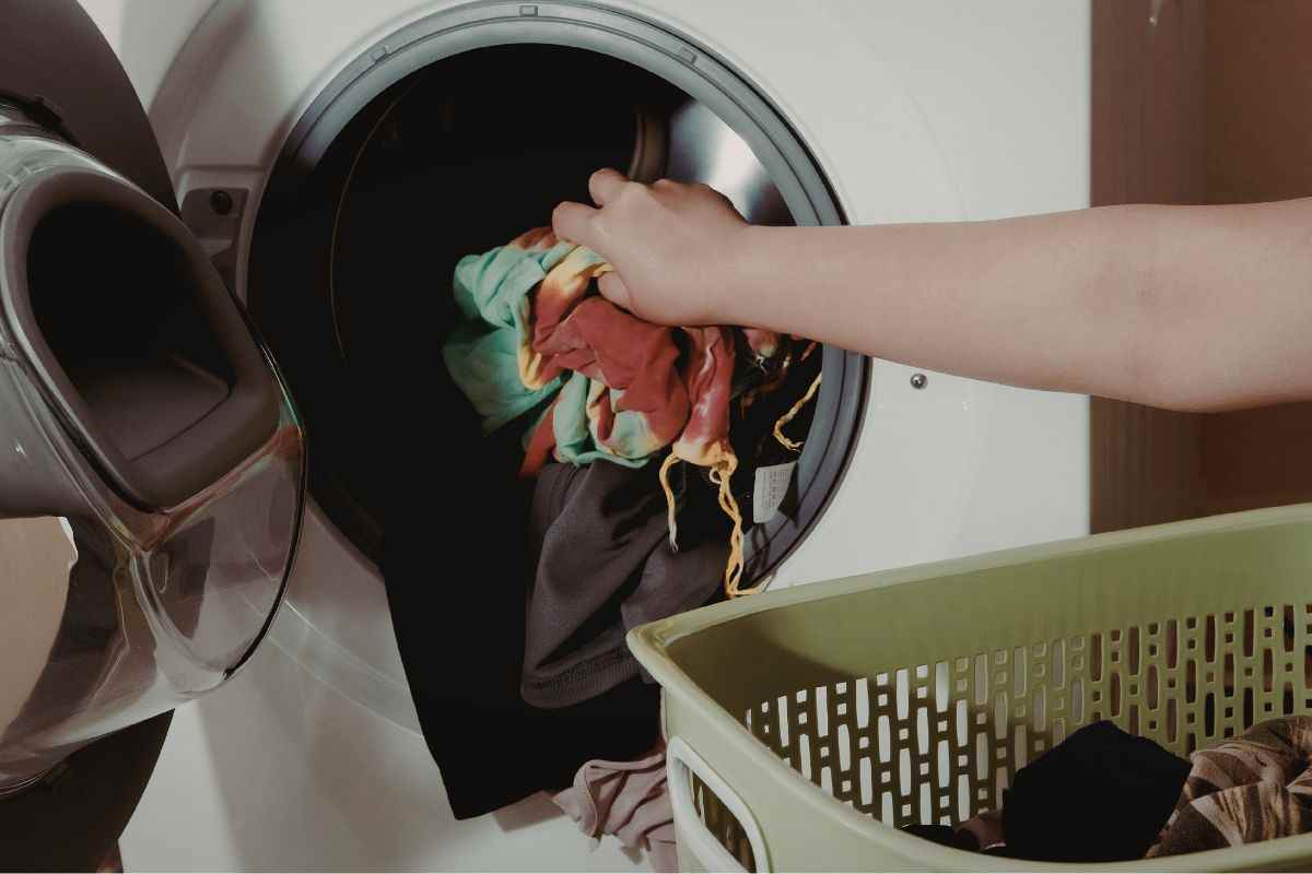 donna con bucato in lavatrice