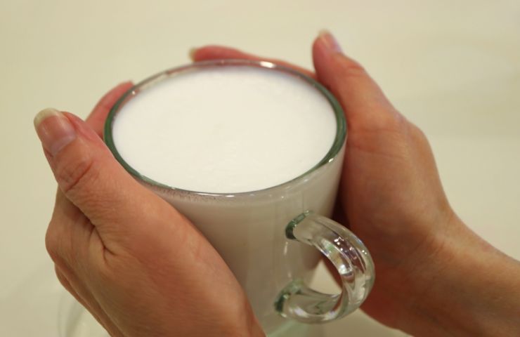 tazza di latte caldo tenuta tra le mani