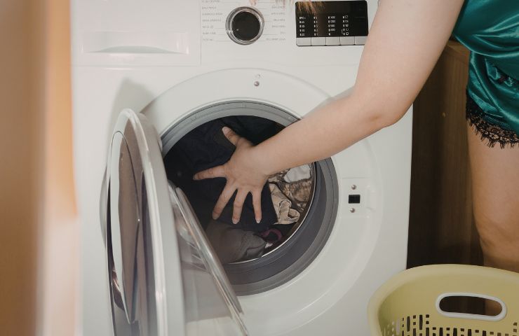 donna prende bucato dalla lavatrice